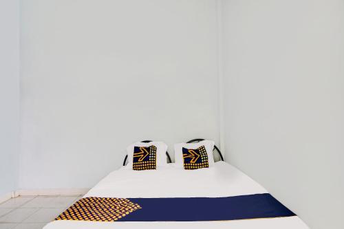 a bed with three pillows on it in a room at Hotel O Sg 99 Homestay Syariah Near SMP N 34 Pekanbaru in Parit