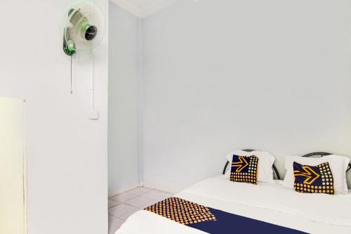 a room with a bed with pillows and a fan at Hotel O Sg 99 Homestay Syariah Near SMP N 34 Pekanbaru in Parit