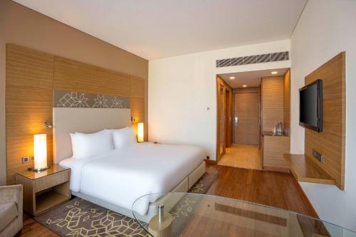 a hotel room with a bed and a television at Radisson Gurugram Udyog Vihar in Gurgaon