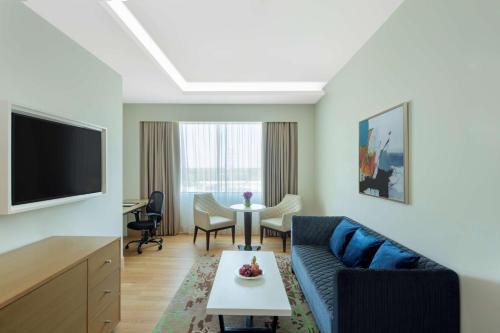 a living room with a couch and a tv at Radisson Gurugram Udyog Vihar in Gurgaon