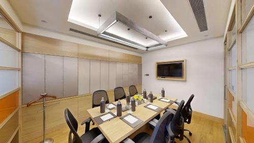 a conference room with a long table and chairs at Radisson Gurugram Udyog Vihar in Gurgaon