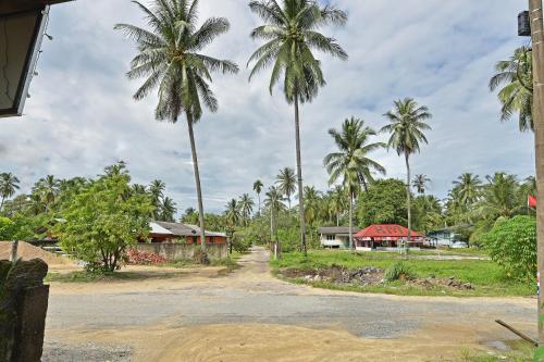 a group of palm trees next to a building at Capital O 90664 Rabi Hotel in Kota Bharu