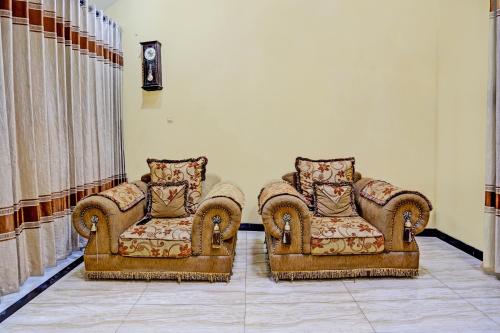 two chairs and a couch in a room at Hotel O Raffa Residence Syariah in Medokanayu