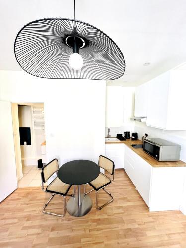 une cuisine avec une table et des chaises dans une cuisine dans l'établissement Superbe appartement centre ville, parking gratuit, à La Rochelle
