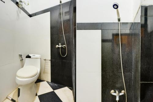a bathroom with a toilet and a shower at SPOT ON 91887 Penginapan Rindu in Nagoya