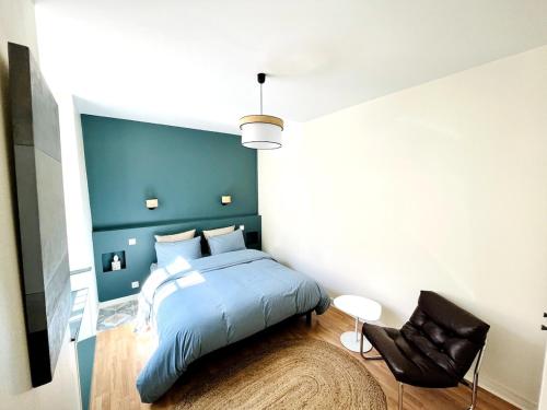 - une chambre avec un lit bleu et une chaise noire dans l'établissement Superbe appartement centre ville, parking gratuit, à La Rochelle