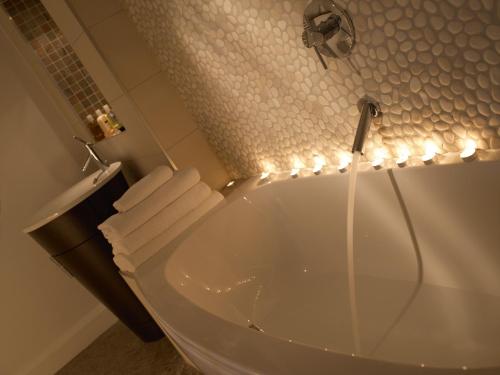 a bathroom with a tub with lights on it at Smiths At Gretna Green Hotel in Gretna Green