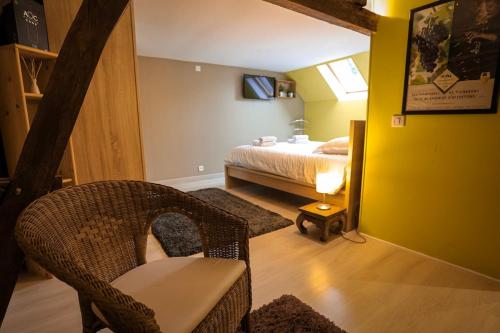 a bedroom with a bed and a chair in a room at La Villa des Roses au cœur de Cormoyeux in Cormoyeux