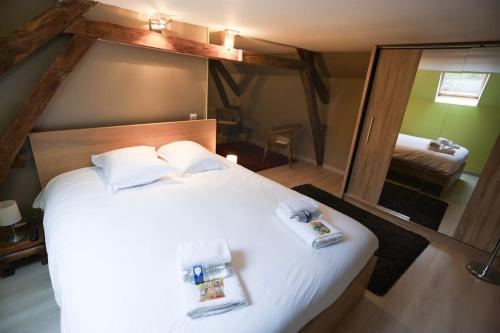 a bedroom with a large white bed with two towels at La Villa des Roses au cœur de Cormoyeux in Cormoyeux