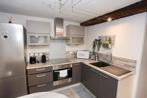 a kitchen with a stainless steel refrigerator and a sink at La Villa des Roses au cœur de Cormoyeux in Cormoyeux