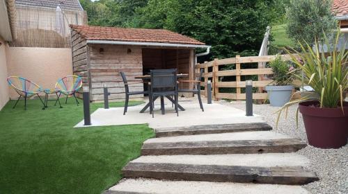 a patio with a table and chairs in a backyard at La Villa des Roses au cœur de Cormoyeux in Cormoyeux