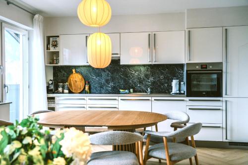 a kitchen with a wooden table and chairs at Spacious boutique family apt w sunny balcony & mountain views in Zell am See