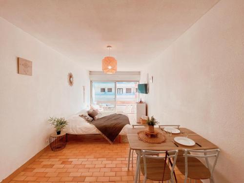 a bedroom with a bed and a table and a window at Studio à 100m de la plage avec balcon - 66 in Canet-en-Roussillon