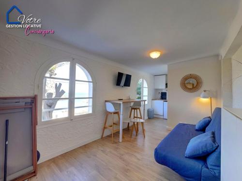 un salon avec un canapé bleu et une table dans l'établissement Le Petit Bear, à Port-Vendres