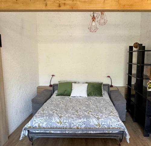 - une chambre avec un lit doté d'oreillers verts et blancs dans l'établissement Domaine Mare e Monti - T1 Le Maquis, à Albitreccia