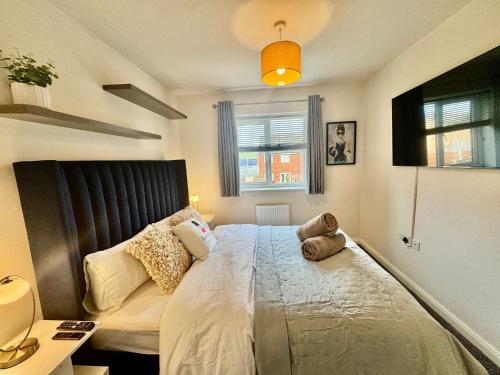 a bedroom with a large bed with a stuffed animal on it at Lapford Luxe - Stylish 3Bdr by Etihad and Coop Live in Manchester