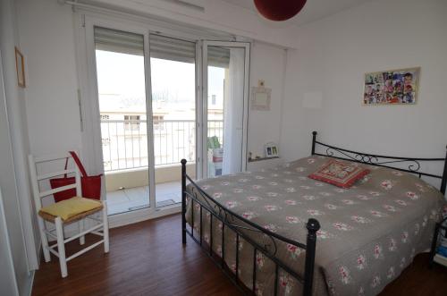 une chambre avec un lit et un balcon dans l'établissement PHOENIX - Appartement 4 personnes avec superbe terrasse, clim et parking le port de Nice, à Nice