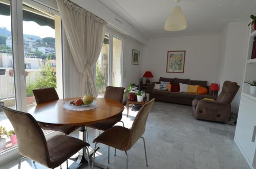 un salon avec une table et des chaises en bois dans l'établissement PHOENIX - Appartement 4 personnes avec superbe terrasse, clim et parking le port de Nice, à Nice