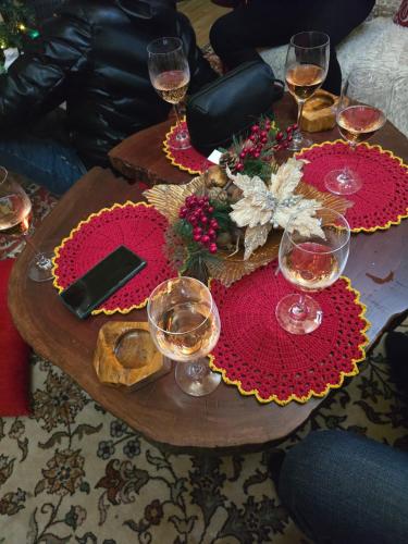 a wooden table with wine glasses and flowers on it at Eni's Villa in Lezhë