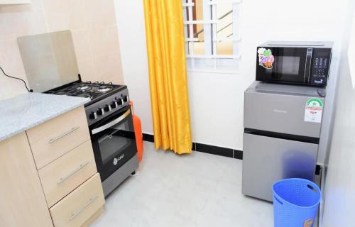 una cocina con estufa y microondas en Kings Sapphire Appartments, en Nakuru