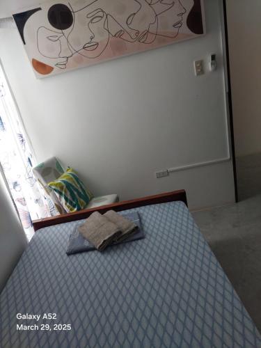 a bed with a towel on it in a room at ASHBURN'S TRANSIENT Bauang LA UNION- SELF CHECK-IN, SELF SERVICE in Bauang