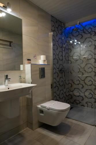 a bathroom with a toilet and a sink and a shower at City Palace Hotel in Ohrid