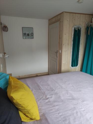 a bedroom with a large bed and a door at La Perlilounette in Le Porge