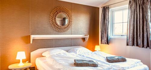 a bedroom with a bed with two bags on it at Chalet park Kroondomein Giethoorn in Giethoorn