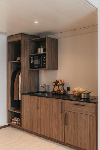 a kitchen with wooden cabinets and a black counter top at IIP Apartments - Self Check-In in Spreitenbach