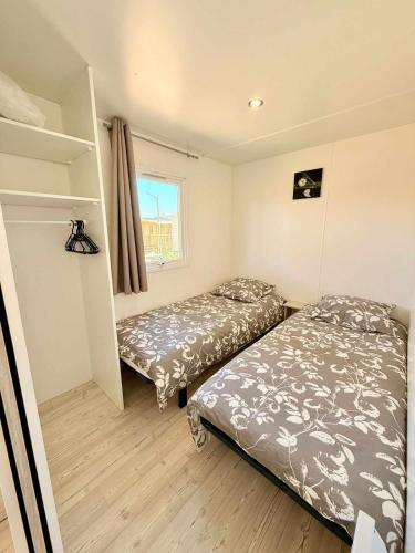 une chambre avec deux lits et une fenêtre dans l'établissement Mar Estang 4 étoiles Camping mobile home, à Canet