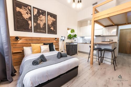 Un dormitorio con una cama y un escritorio y una cocina. en Living4malaga Woodland Oasis, en Málaga