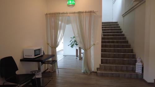 a room with a staircase with a microwave and a television at Lapin Satu in Posio