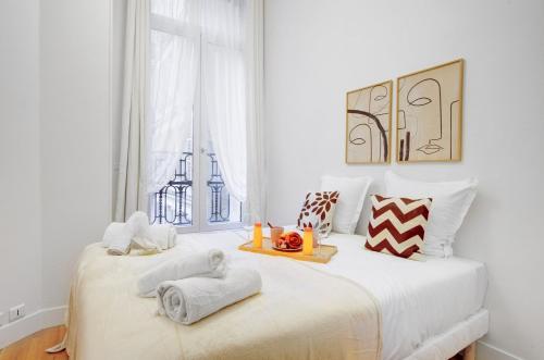 une chambre blanche avec un lit avec des serviettes dessus dans l'établissement 5013 Kleber Suite - Suite near Arc de Triomphe, à Paris