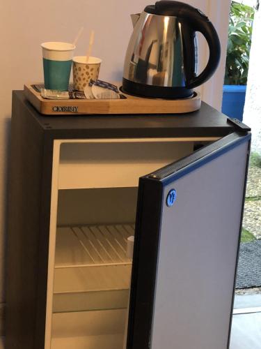 an open refrigerator with a kettle on top of it at Hotel Des 4 Vents "Esprit Camargue" Parking Privé securisé in Aigues-Mortes