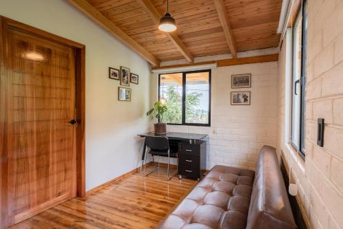 a room with a couch and a desk and a window at Salinas Luxury Home in the Mountains in Guaranda