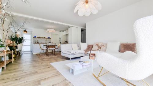 un salon avec un canapé blanc et une table dans l'établissement Le petit bonheur avec Jardin - T3, à Jebsheim