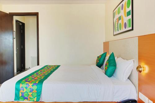 a bedroom with a large white bed with green pillows at Treebo Premium Ocean Echo, Rushikonda in Rushikonda