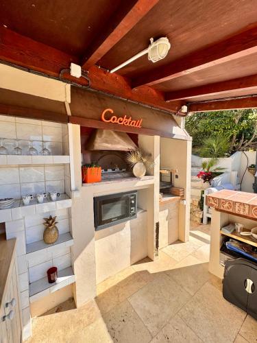 une cuisine avec un îlot de cuisson au milieu dans l'établissement maison en duplex avec jardin, à Cagnes-sur-Mer