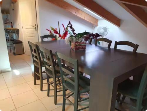 une table à manger avec des chaises et une table avec des fleurs dans l'établissement Appartement Paglia Orba Rivière & maquis, à Manso