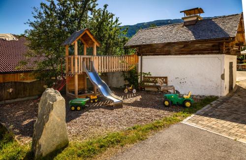 a playground with a slide and a play house at Dorfergut in Weisspriach