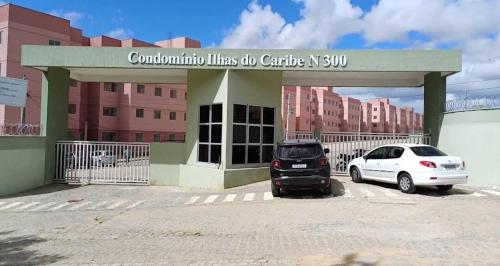 two cars parked in a parking lot in front of a building at A 7 minutos da base aérea de natal in Parnamirim