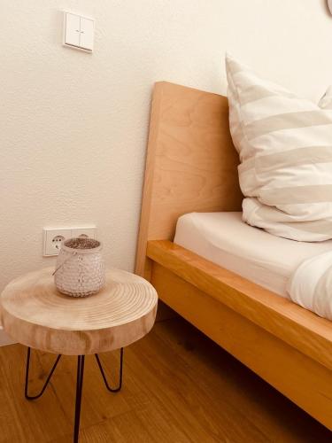 a bed with a table next to a bed with a pillow at AlbLoft - Modernes neues Apartment nahe City & Alb für bis zu 6 Personen in Kirchentellinsfurt in Kirchentellinsfurt