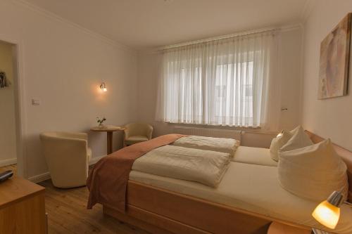 a bedroom with a large bed and a window at Hotel Sonnenklause in Travemünde