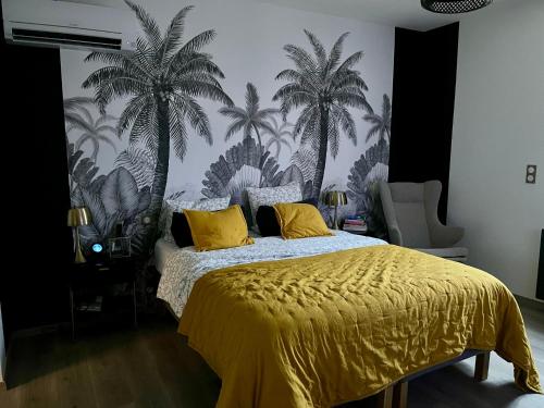 - une chambre dotée d'un lit jaune avec des palmiers sur le mur dans l'établissement Le Mas des platanes-piscine-gîte-Clim-parking, à Monteux