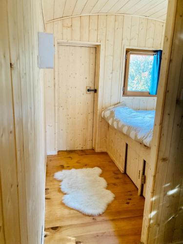 une petite pièce avec un lit et une fenêtre dans l'établissement Roulotte atypique à l'Océan, à Labenne
