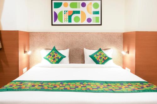 a bedroom with a large white bed with colorful pillows at Treebo Premium Ocean Echo, Rushikonda in Rushikonda