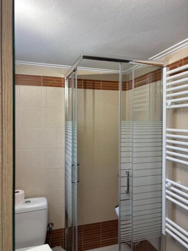 Un baño con ducha de cristal con inodoro. en Little Diamond Stay, en Mytilini