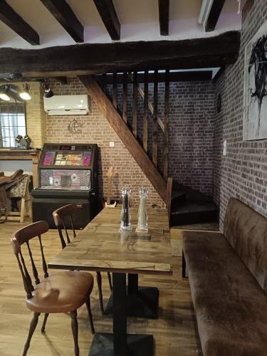 a dining room with a wooden table and chairs at La Taverne de la Zibetterie in Saint-Privé