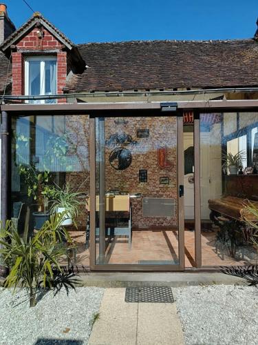 an extension to a house with sliding glass doors at La Taverne de la Zibetterie in Saint-Privé