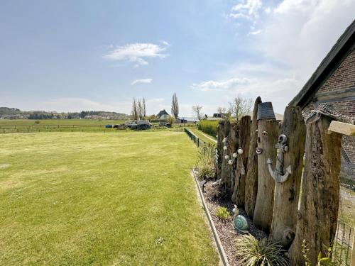a wooden fence in front of a field at Haus Inselperle mit Blick auf den Bodden in Alt Reddevitz